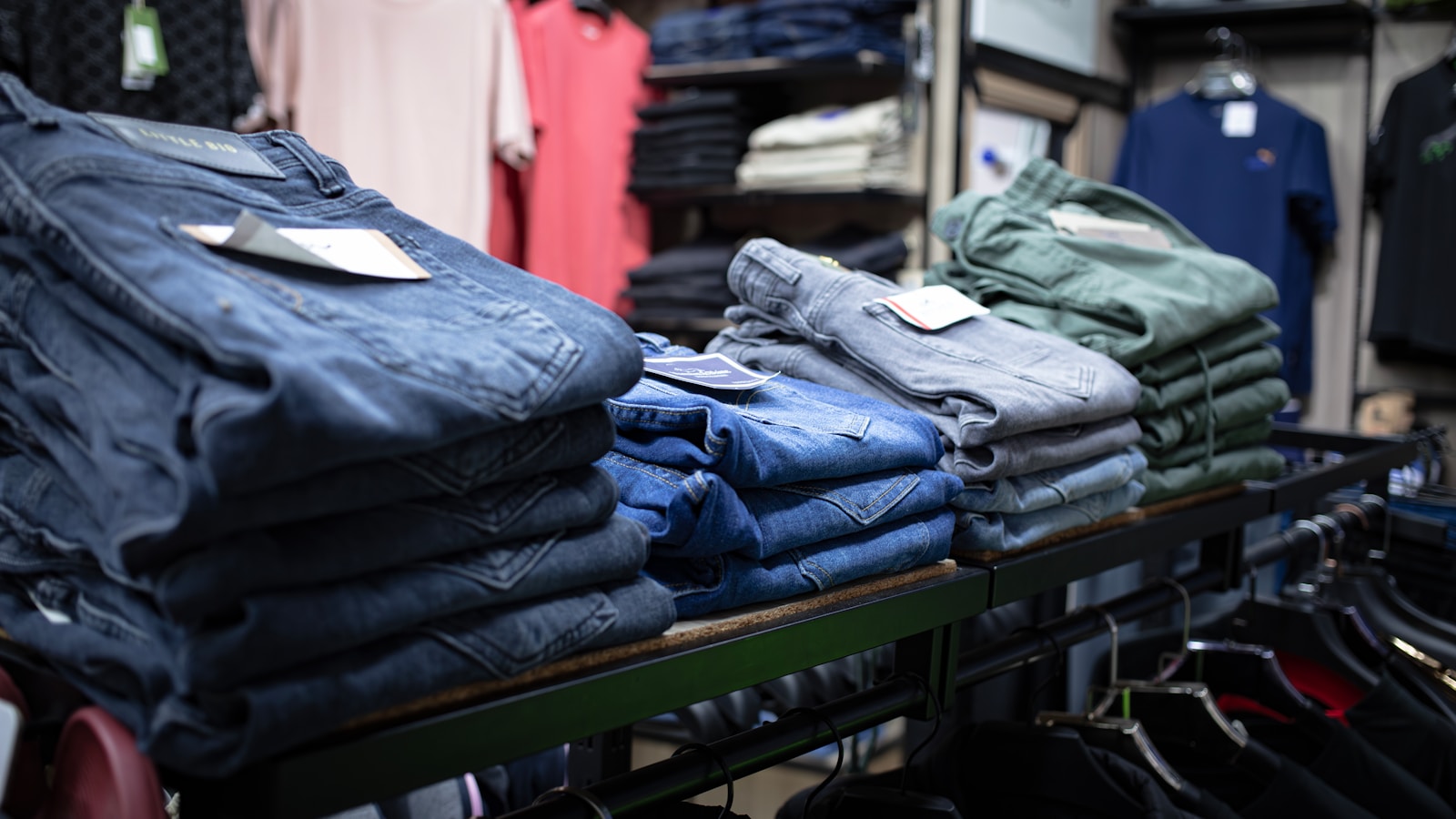 a rack of folded jeans in a clothing store