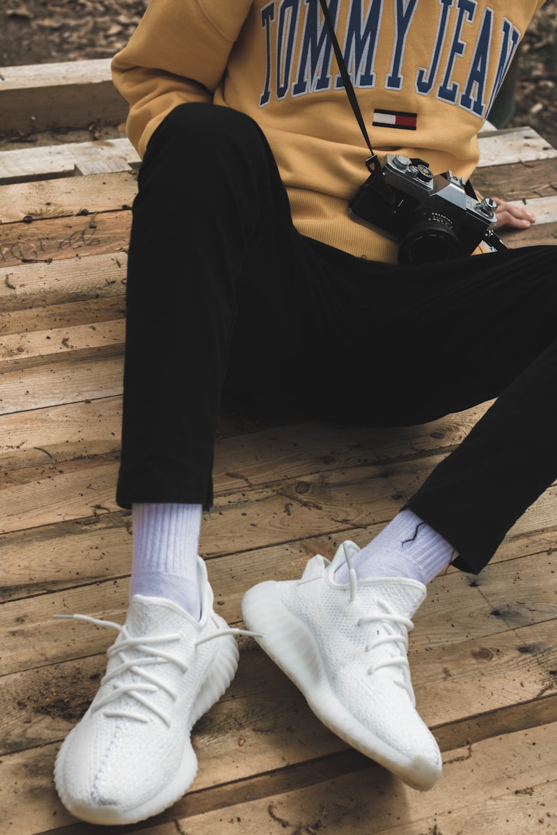 person in black pants and white socks sitting on brown wooden floor